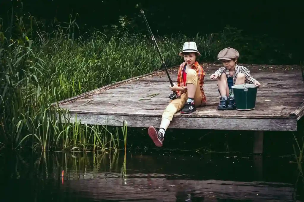 children fishing in a lake